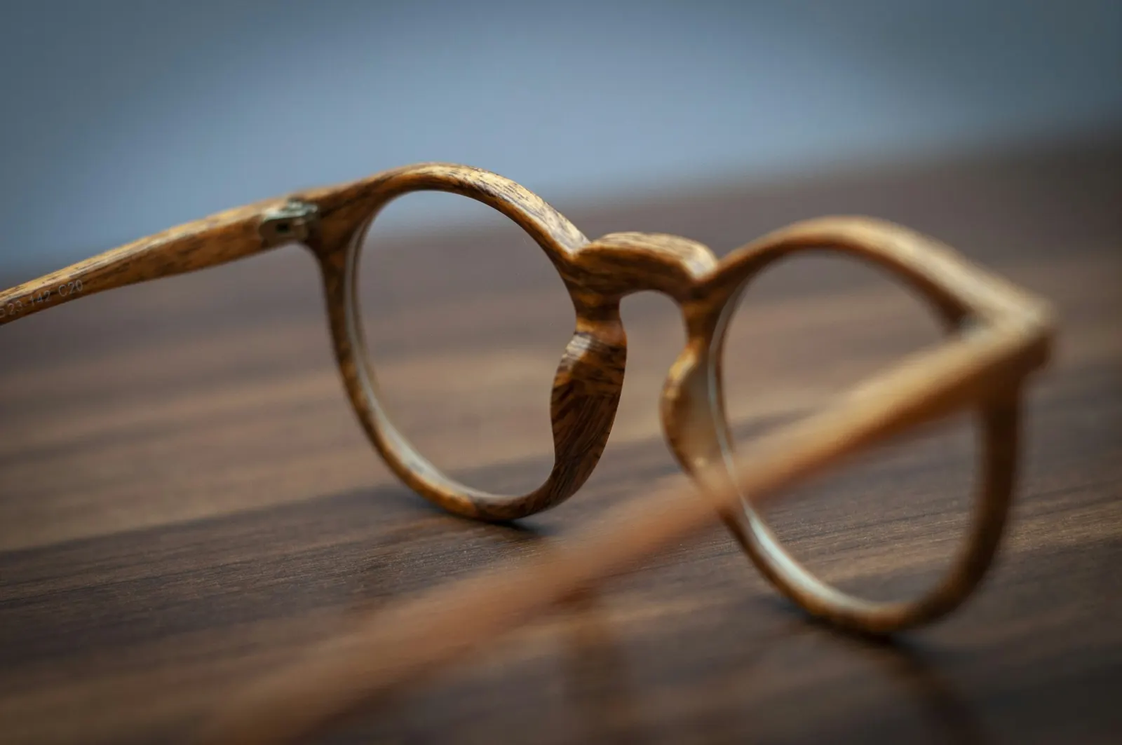 A pair of round eyeglass frames on a wooden table