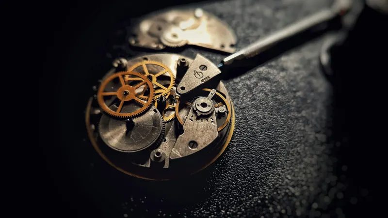 An open mechanical watch movement on a dark surface